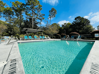 a swimming pool with blue chairs and a resort style pool